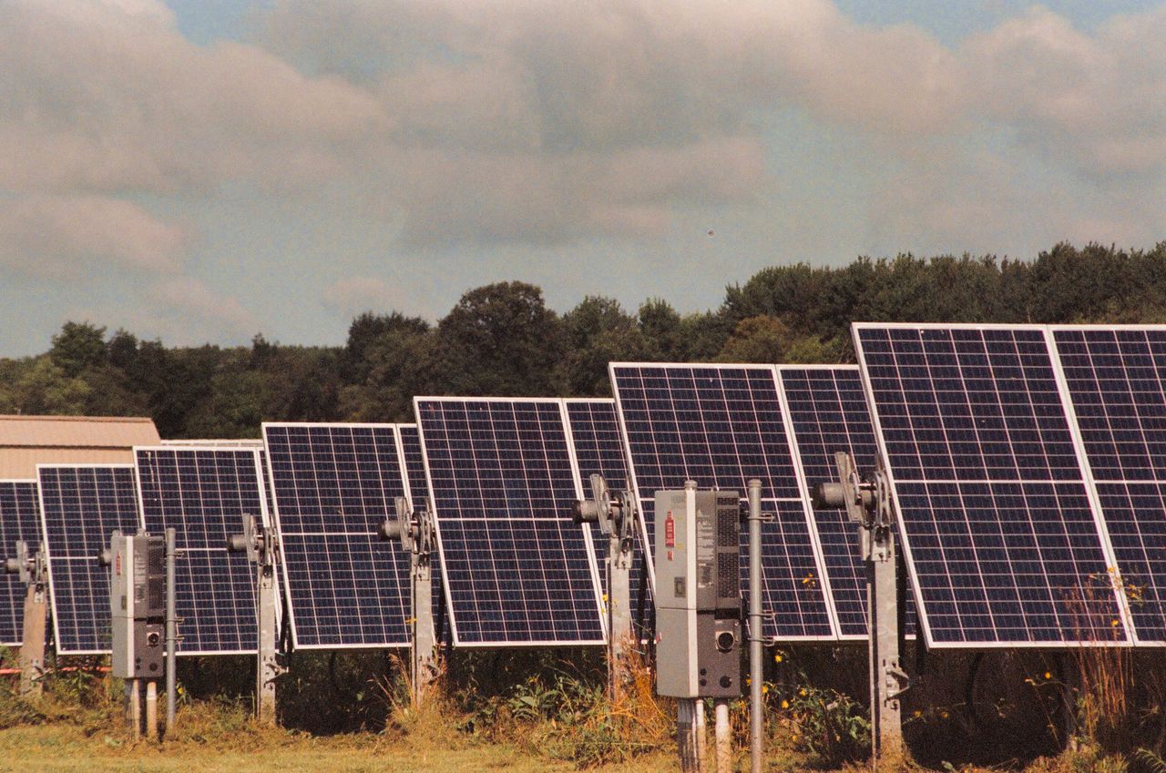 services-02 Solar panels in a field generating clean, renewable energy on a sunny day.