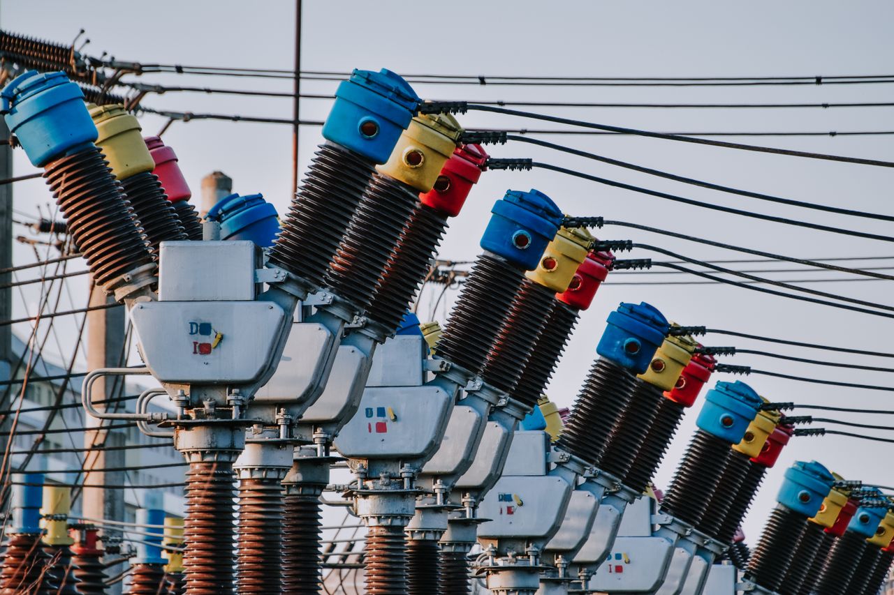 Mastering the First Impression: Your intriguing post title goes here Close-up of electrical transformers with colorful tops and wires in an outdoor setting.